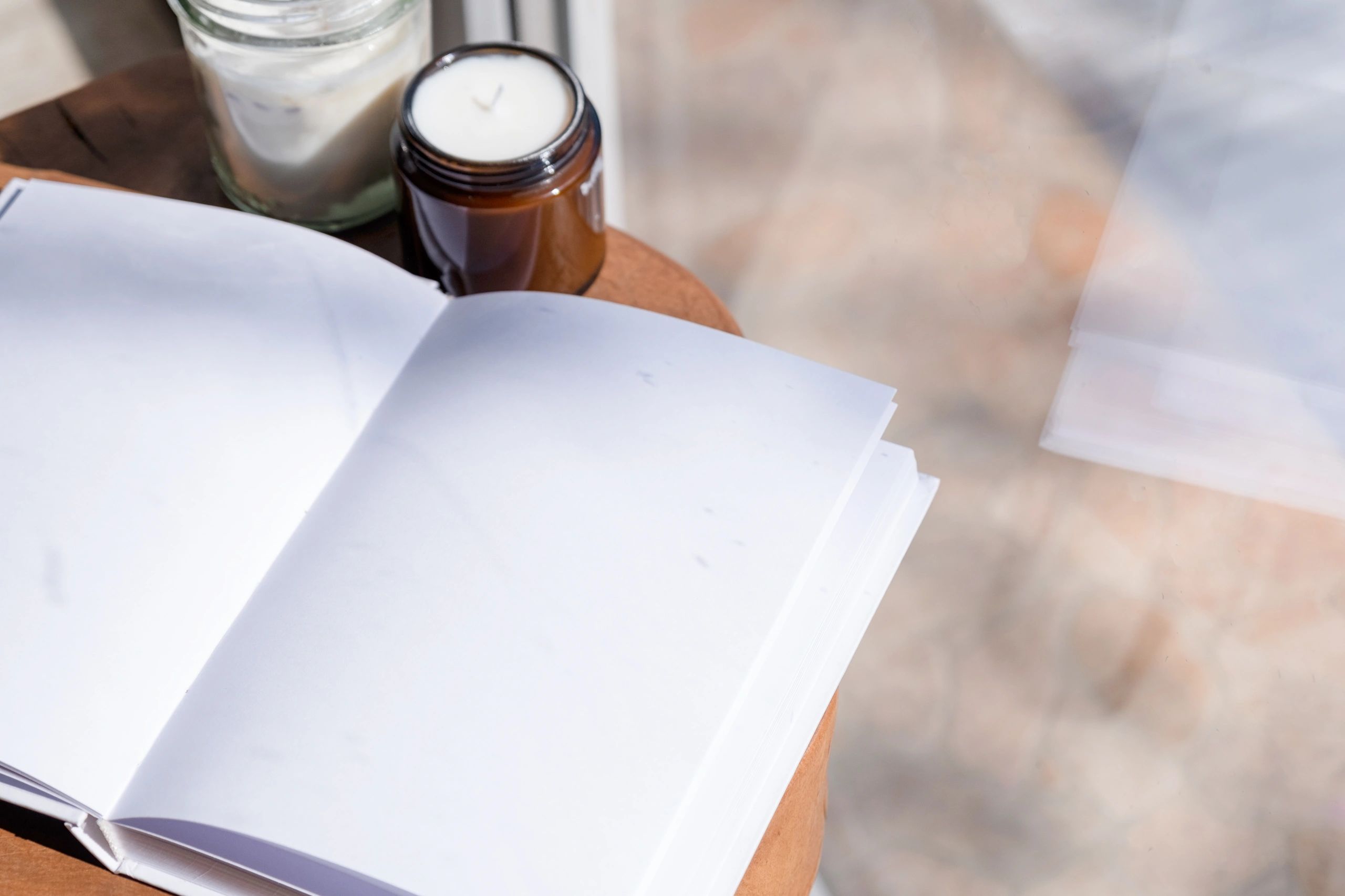 Open journal on a wooden table with candles