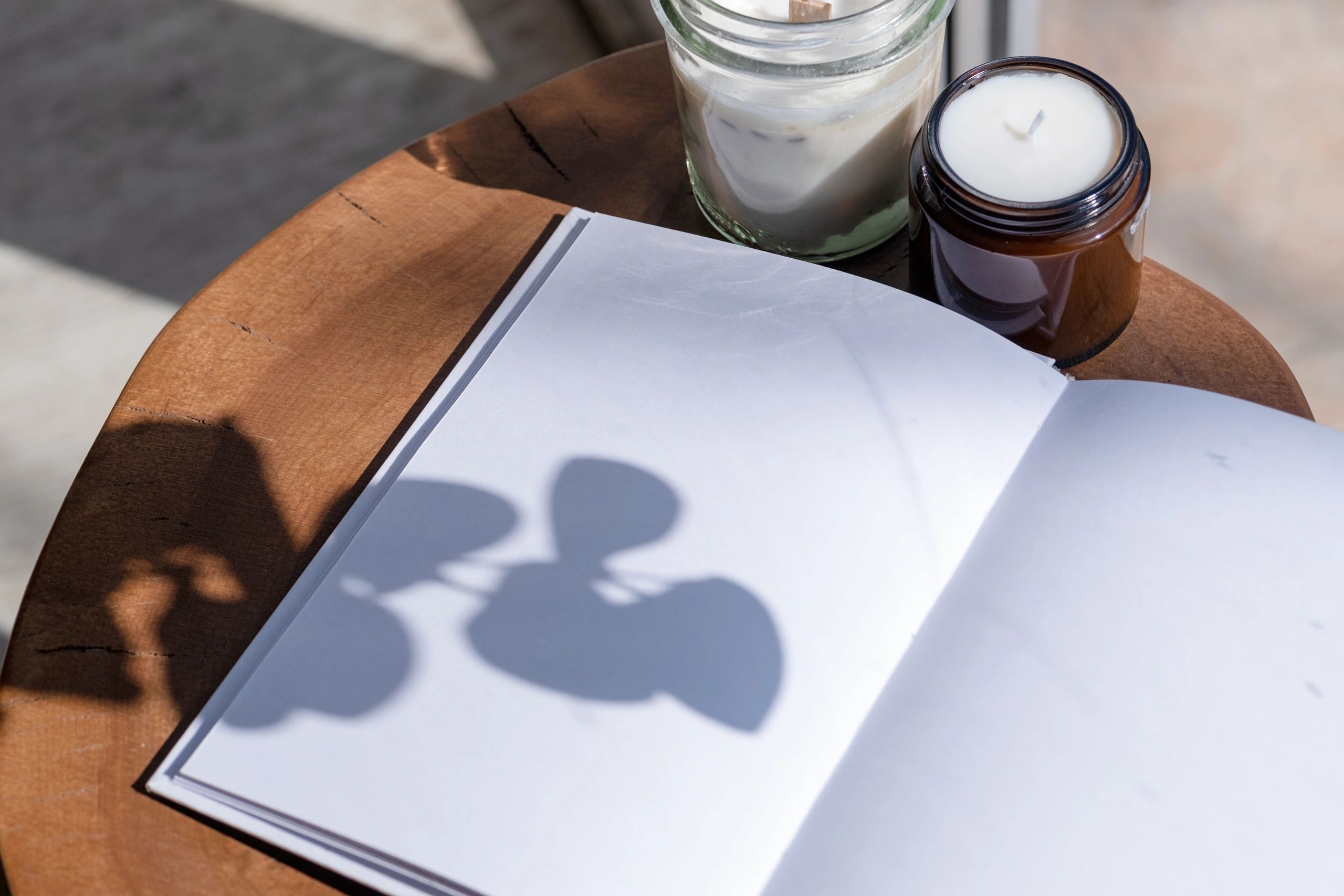 Open journal on a wooden table with candles